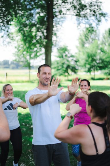 Gruppentraining im Freien mit einem Trainer und mehreren Teilnehmern. sonniger Tag.